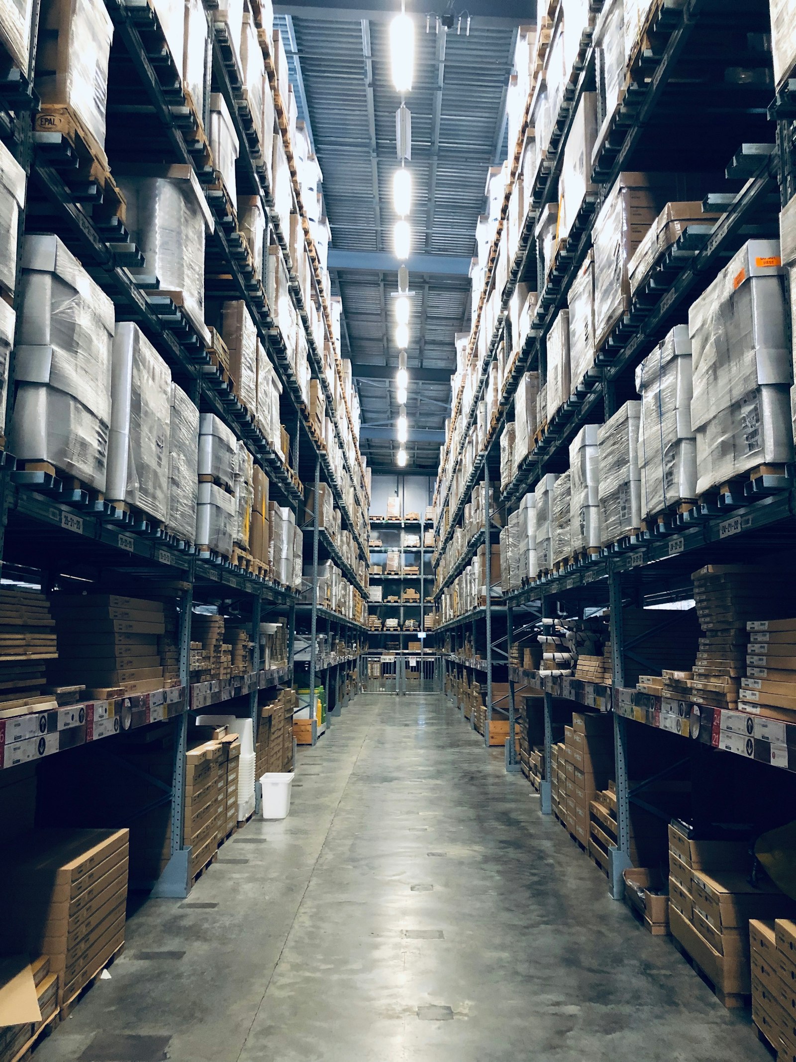 Aisle of a high-bay warehouse stacked with palletised stock